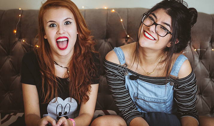 two women having fun on a couch