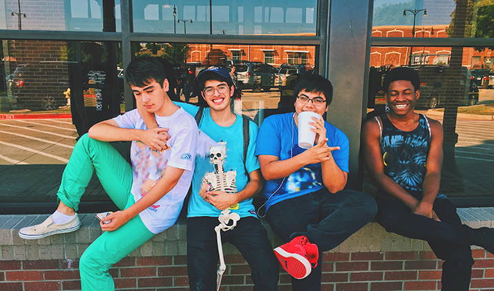 group of friends sitting on a wall