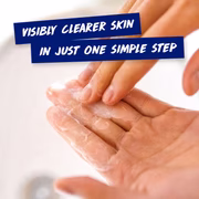 Hands spreading Clearasil cleanser with message: visibly clearer skin in one step